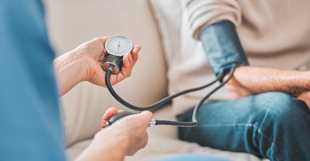 medicinsko osoblje meri pritisak muškarcu